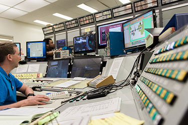 man sitting at lab control board