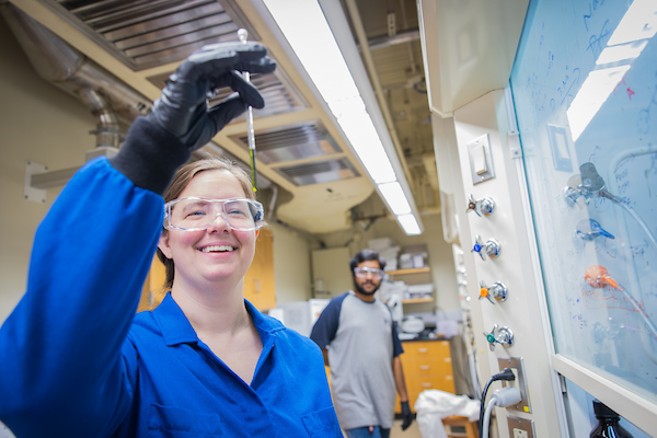 Student looking at the contents of a chemistry beaker