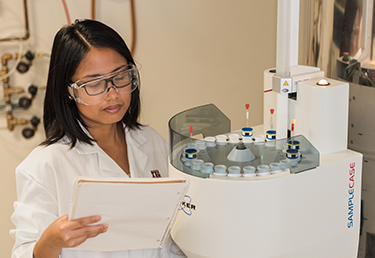 young lady in lab coat reading notes