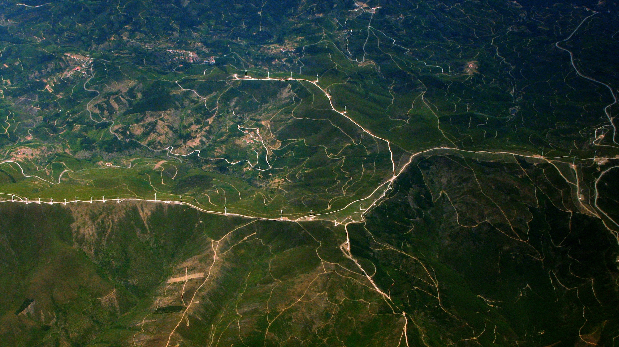 arial view of land with a large group of windmills visible 