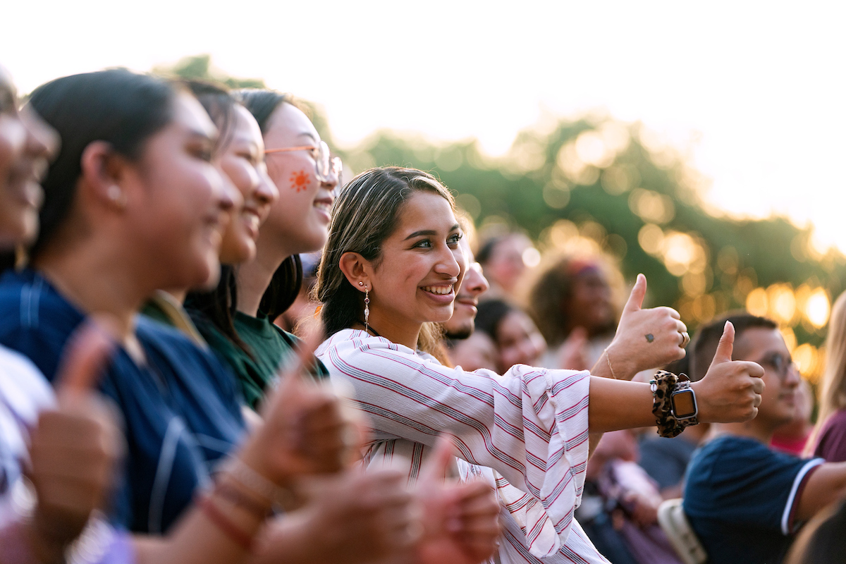 Texas A&amp;M Students offering a gig em in the sunlight