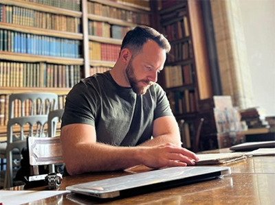 Tanner Ogle reading in a library setting