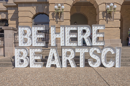 Lighted letters which read, Be Here, Be ArtSci