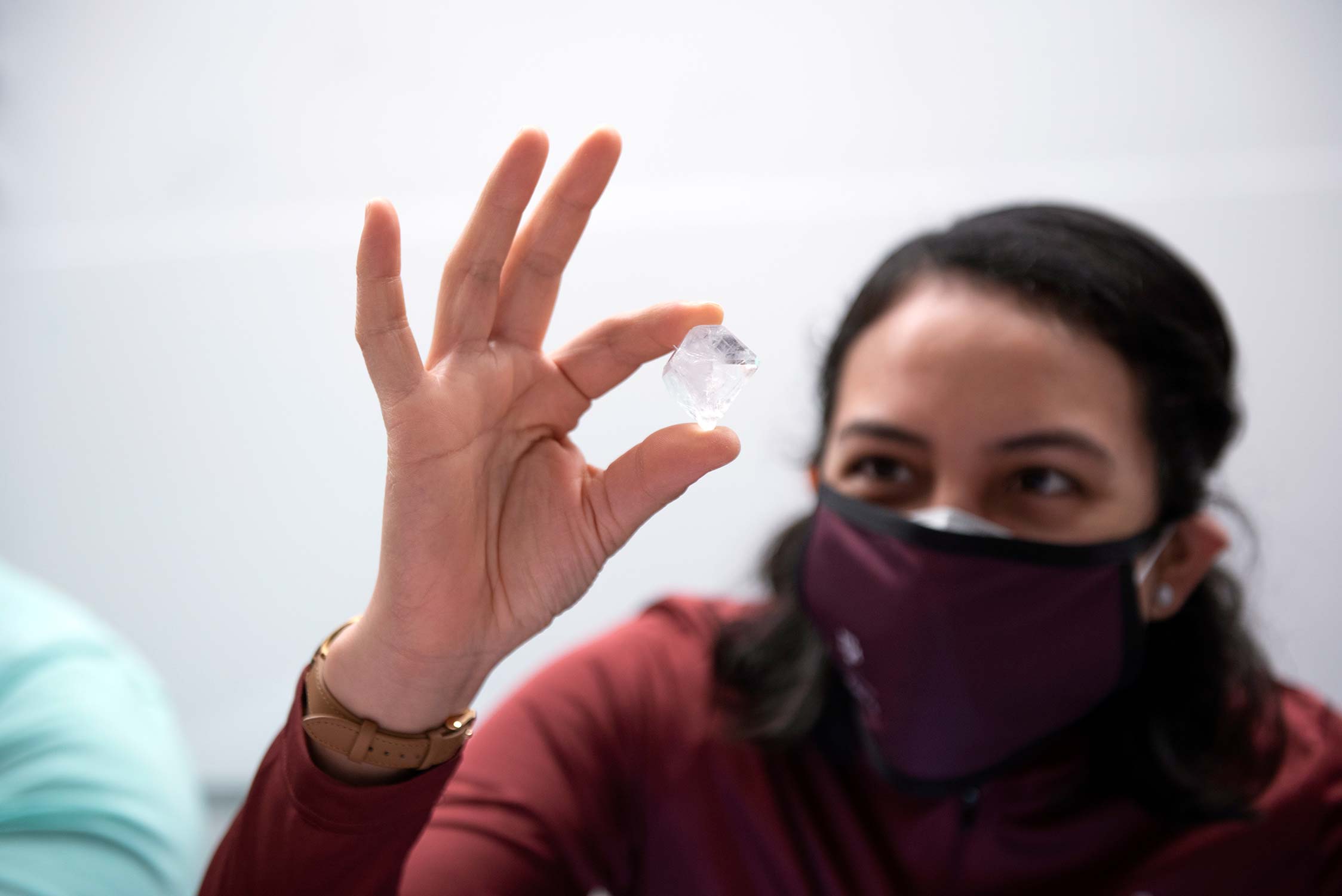 Texas A&M chemistry graduate student Lupita Aguirre '22 takes a closer look at one of the nearly 170 crystal entries submitted for the 2021 U.S. Crystal Growing Competition., judged at Texas A&M University