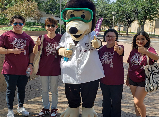 The Texas A&M Chemistry mole poses with several chemistry students at the 2022 Chemistry Open House