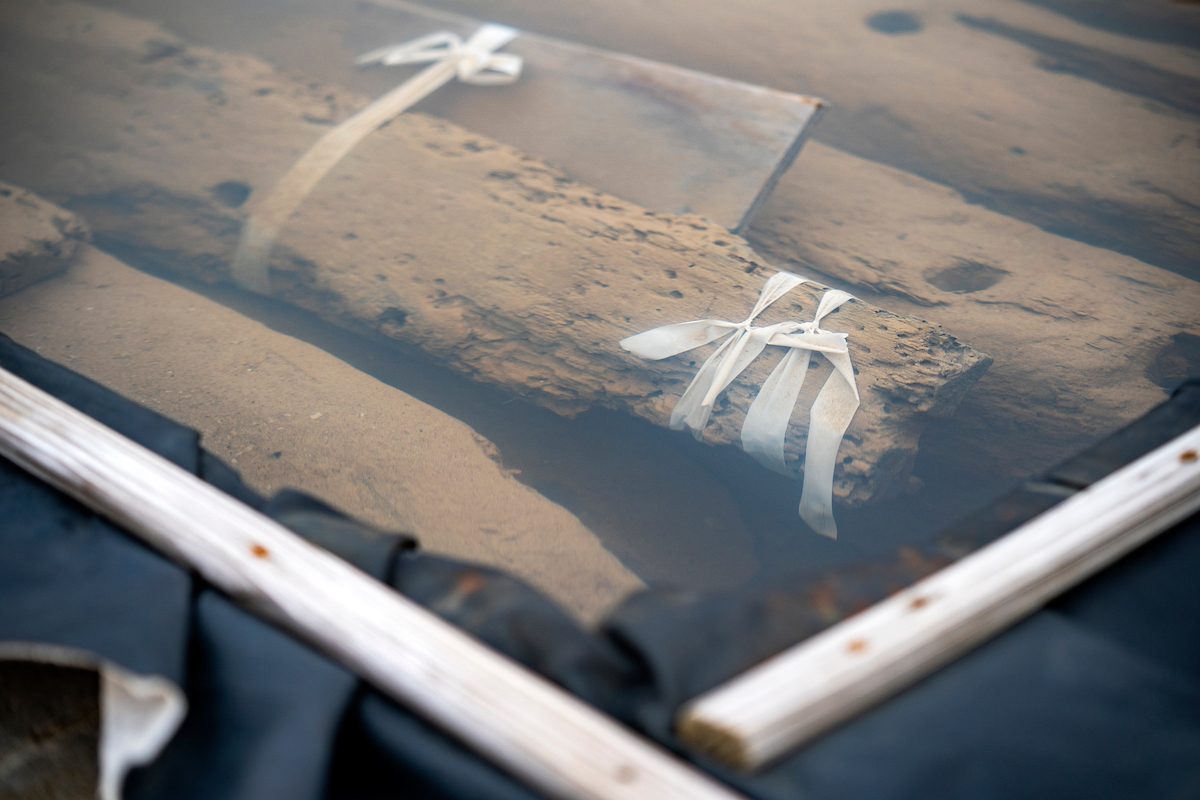 Pieces of a ship submerged in vats of liquid at the Conservation Research Laboratory