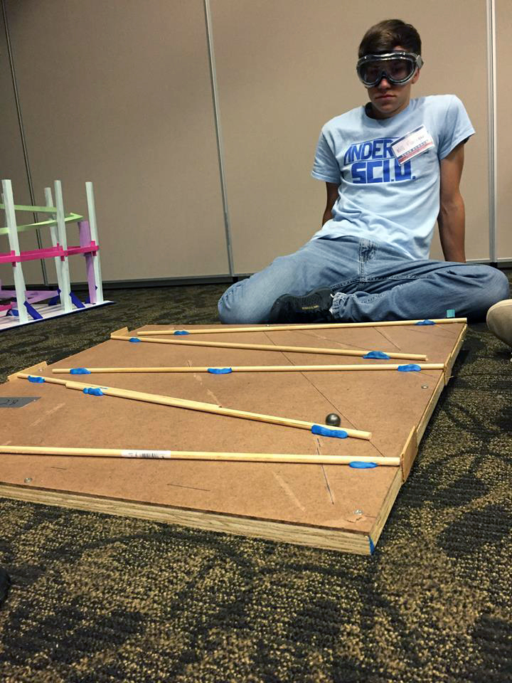 A high school student moves a marble through a rollercoaster during a Texas Science Olympiad event