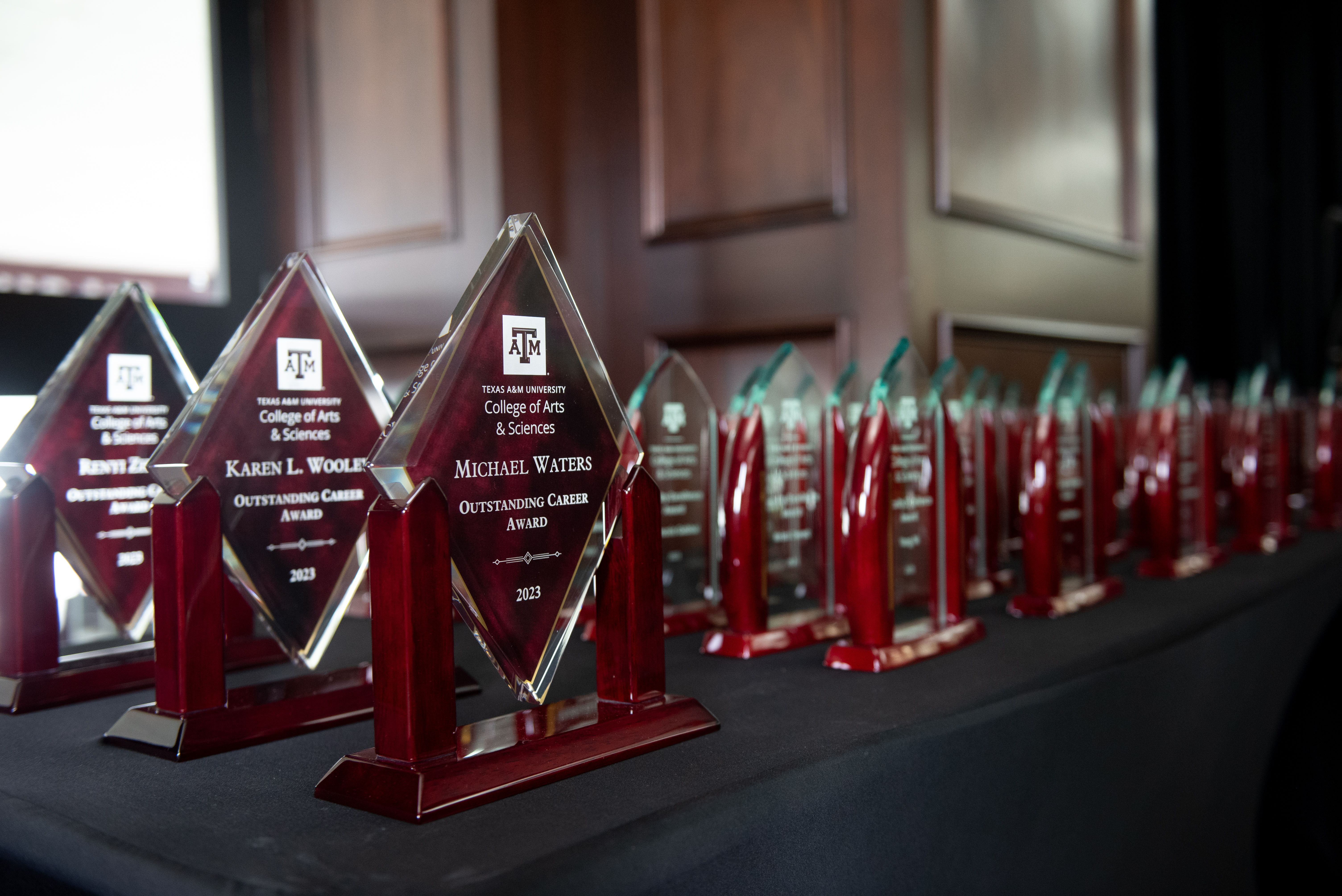 Plaques honoring Texas A&M University College of Arts and Sciences award winners lined up on table awaiting presentation 