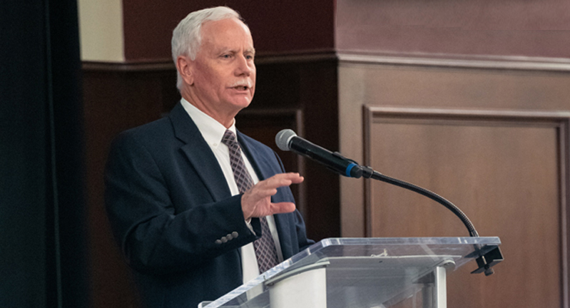 Texas A&M biologist Mark Zoran at the podium in The Zone Club at Kyle Field