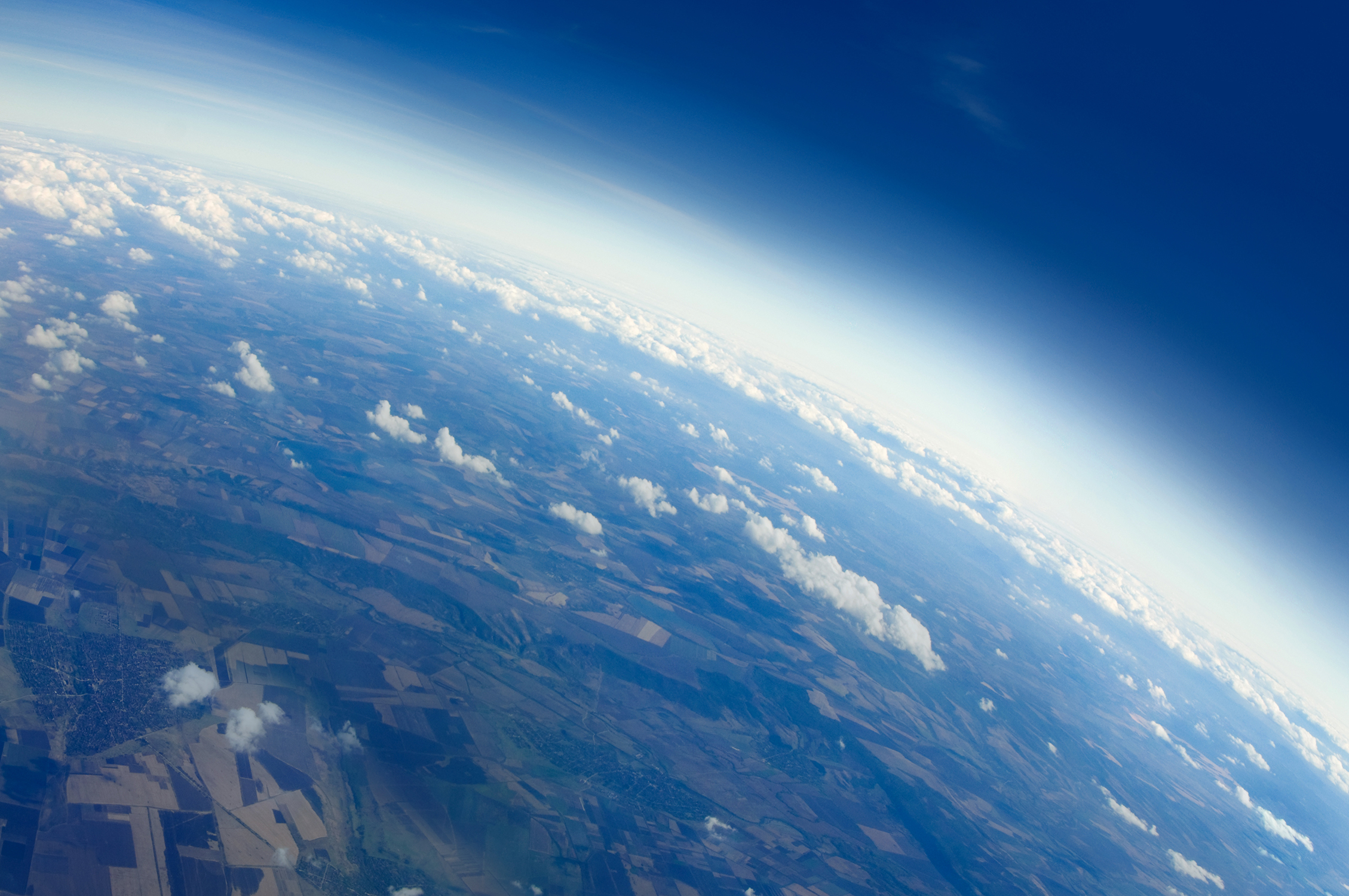 Aerial view of Planet Earth with clouds, horizon and little bit of space
