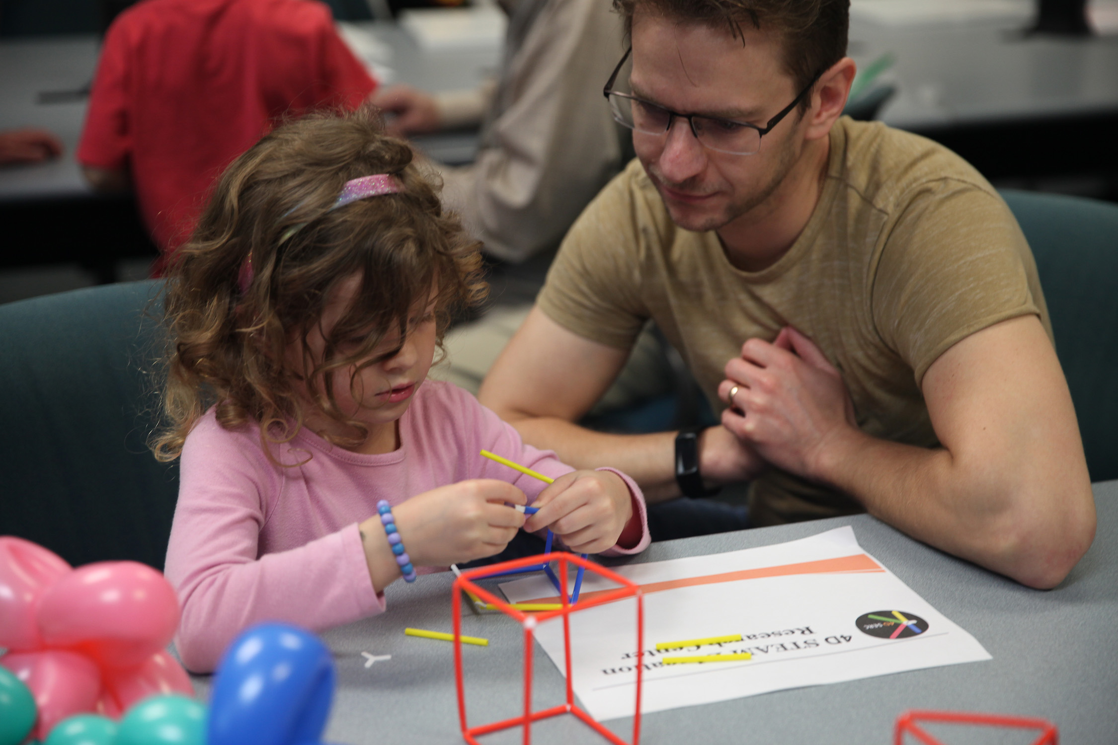 A father and his daughter participate in a craft event at the 2023 Texas A&M University Math and Stat Fair