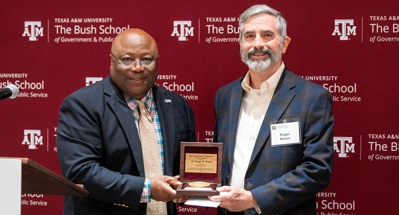 Texas A&M University history professor Roger Reese accepts his award from Bush School Interim Dean Dr. Frank Ashley
