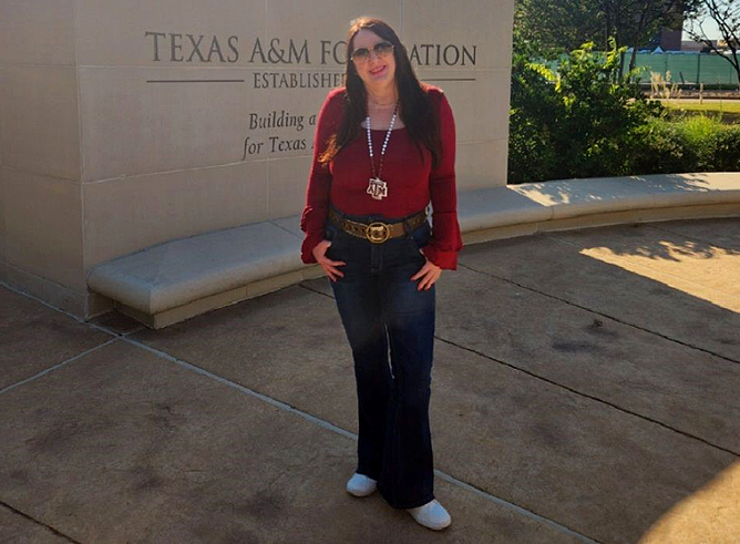 1990 Texas A&amp;M University English graduate Susan Smallman, standing in front of the Texas A&amp;M Foundation sign on the Texas A&amp;M campus