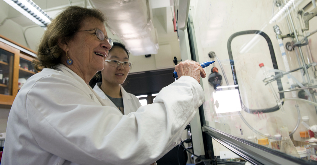 Texas A&amp;M University chemist Marcetta Darensbourg instructs a student in her lab wearing safety goggles and a white lab coat