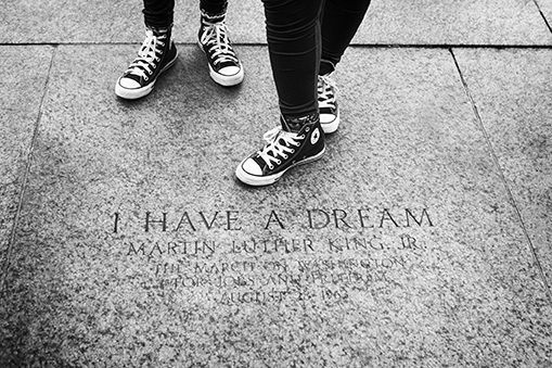 Washington DC, USA - June 2017: Youth in their sneakers standing by the marker engraving memorializing the location of where Martin Luther King made his famous "I have a Dream" speech.