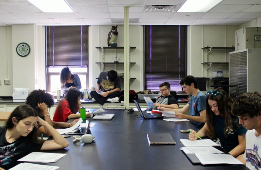 Students working in Dr. Butler’s lab sitting at a large desk.