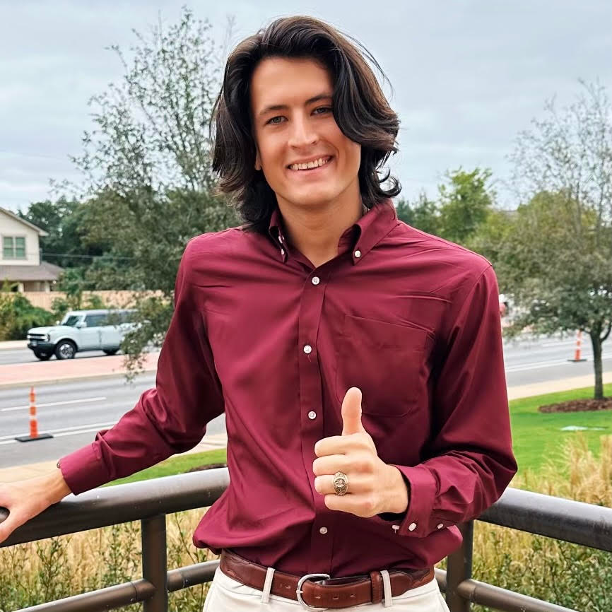Parker Doucette in a maroon shirt smiling and giving a thumbs up, standing outdoors with a residential area in the background.