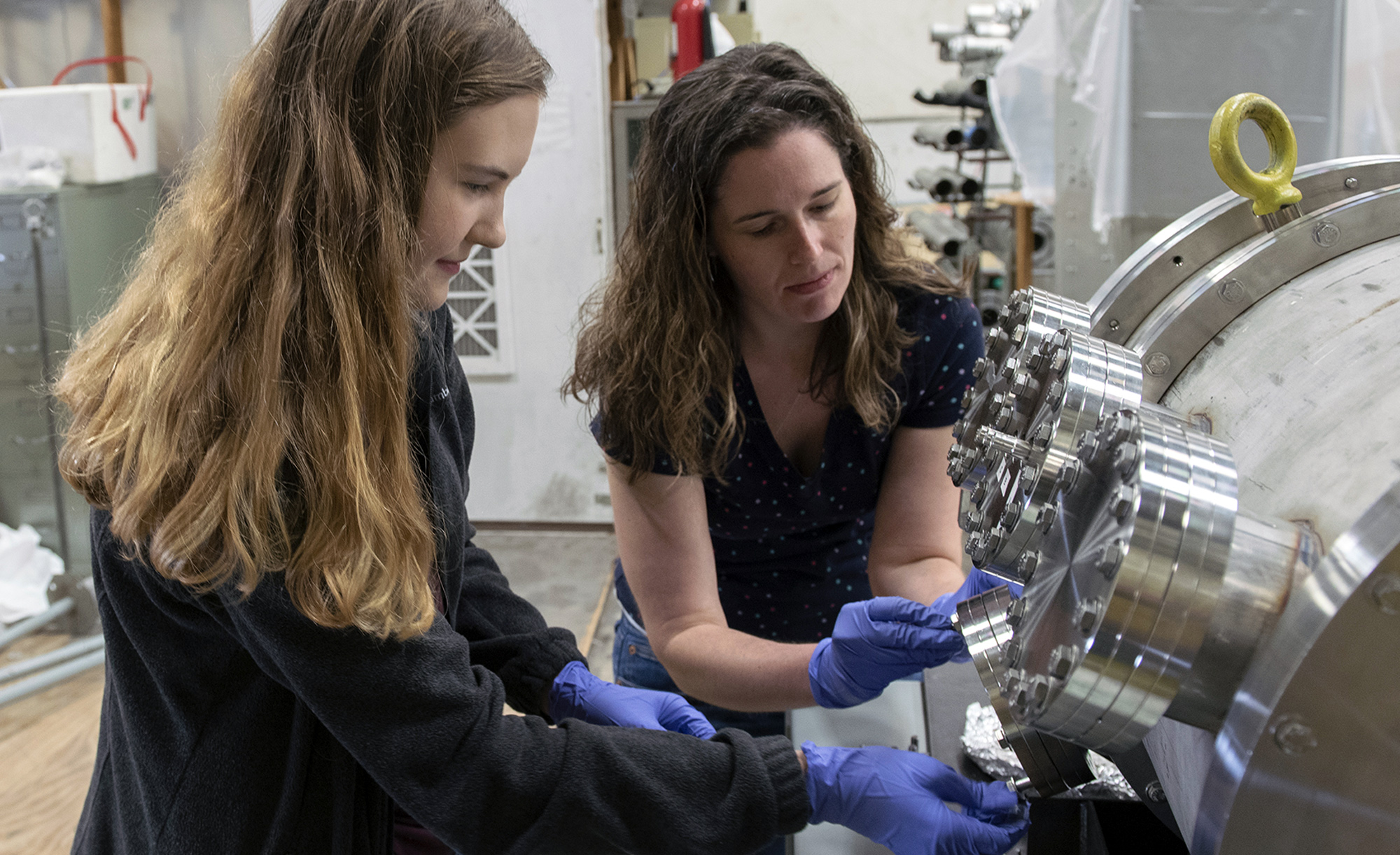 Two female researchers work to calibrate equipment settings within the Cyclotron Institute at Texas A&amp;M University.