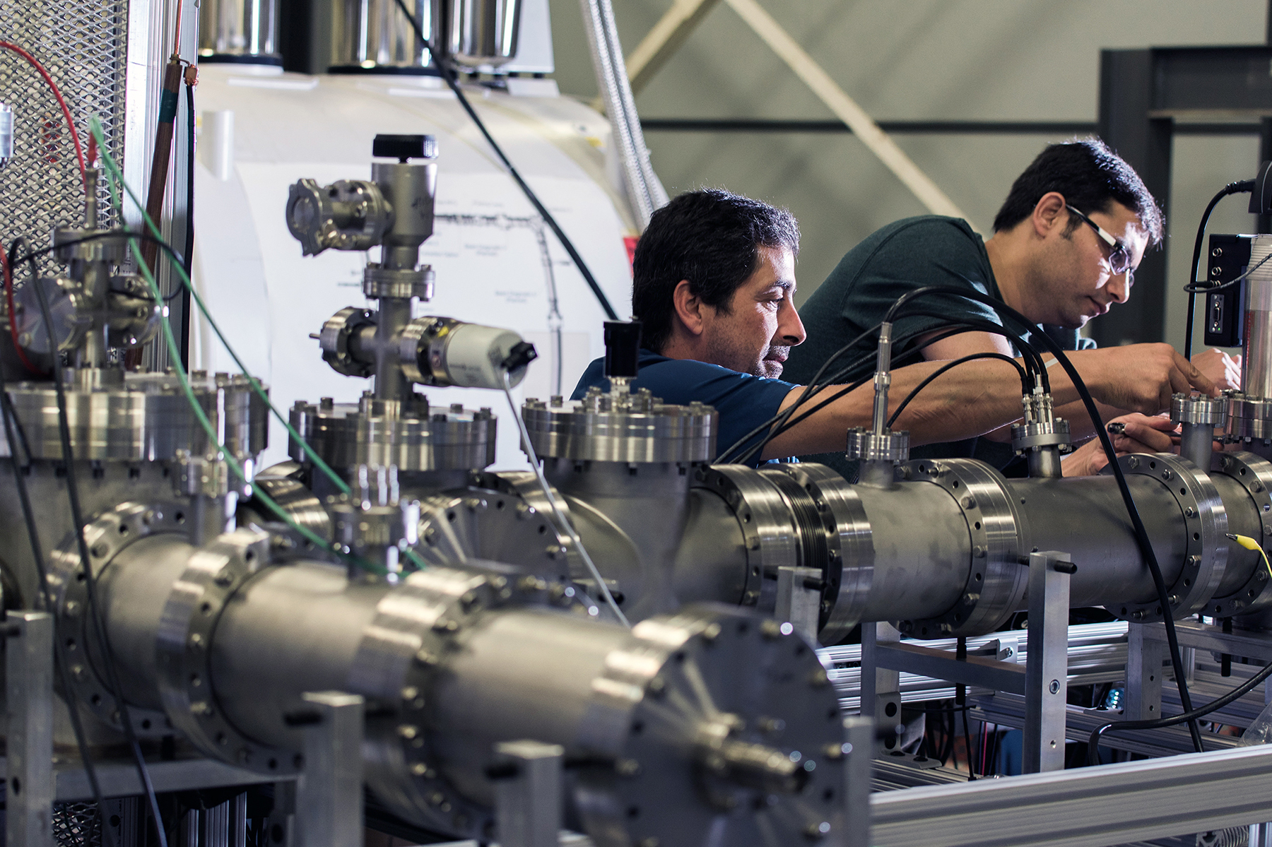 Two researchers work on a Penning trap designed to capture and purify short-lived ions for precision decay experiments within the Cyclotron Institute at Texas A&M University.