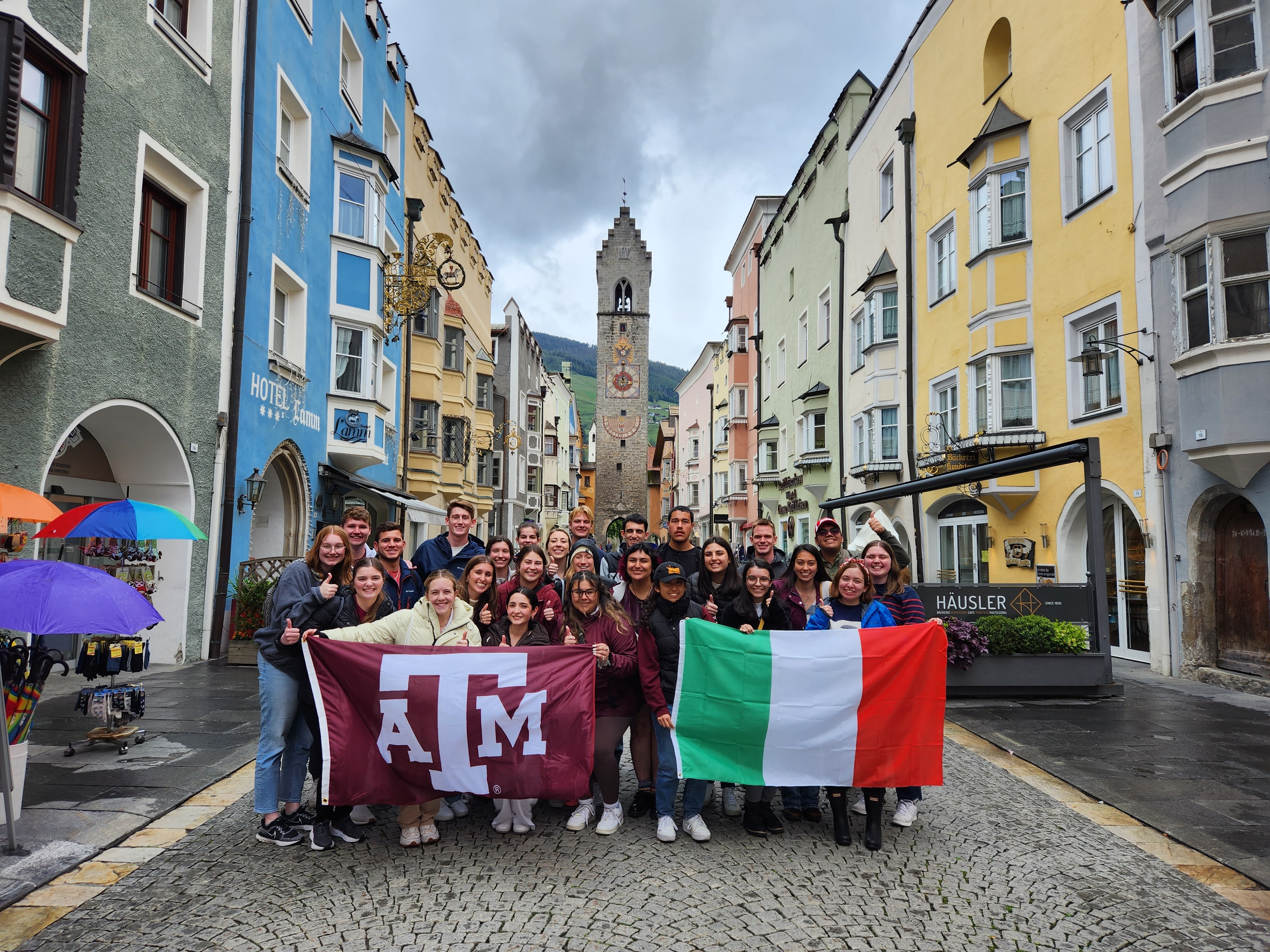group of students in Italy holding up flags
